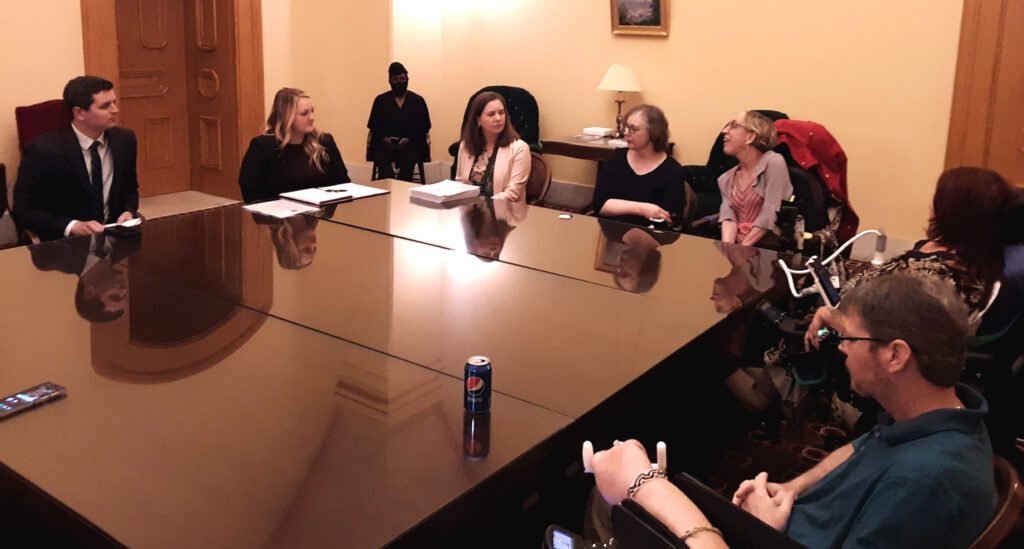 Advocates sitting at a conference table in a committee meeting at the Ohio State Capital.