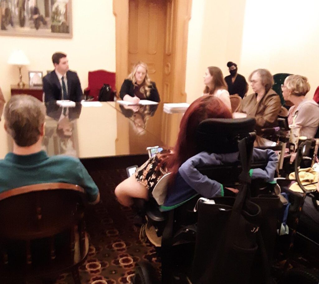 Advocates sitting at a conference table in a committee meeting at the Ohio State Capital.